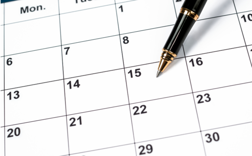 Picture of a pen pointing to a calendar.